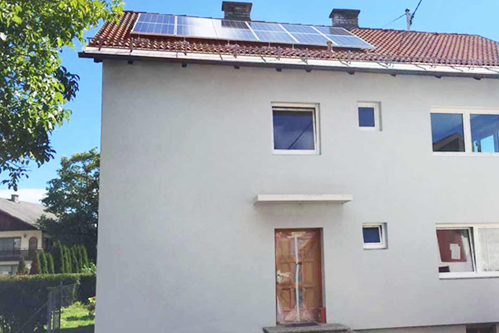 Weißes Einfamilienhaus mit Photovoltaikanlage am Dach