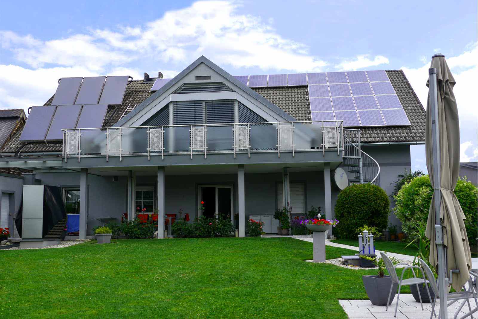 Blaugraues Einfamilienhaus mit Wärmepumpe und Photovoltaik am Dach